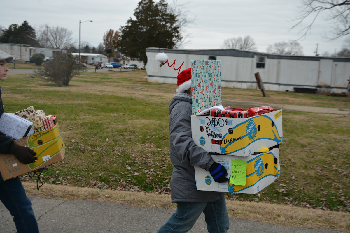 Volunteers carrying gift boxes.