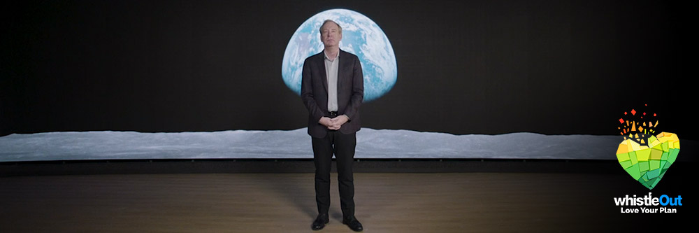 Brad Smith, President of Microsoft, standing in front of a photo of the Earth as seen from the moon.
