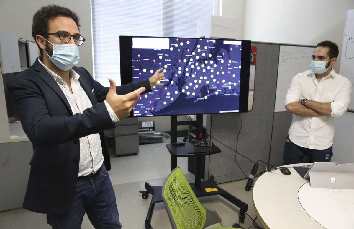 Elias Bou-Harb works with Morteza Safaei Pour and his staff researching the increasing hacking of smart devices during the coronavirus pandemic on Sept. 3, 2020. The screen displays locations on a world map where device hacking is ocurring.