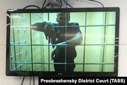 Russian opposition leader Aleksei Navalny -- who has been jailed in a notorious prison east of Moscow since February -- is seen on a screen via a video link during a court hearing in Moscow in June.