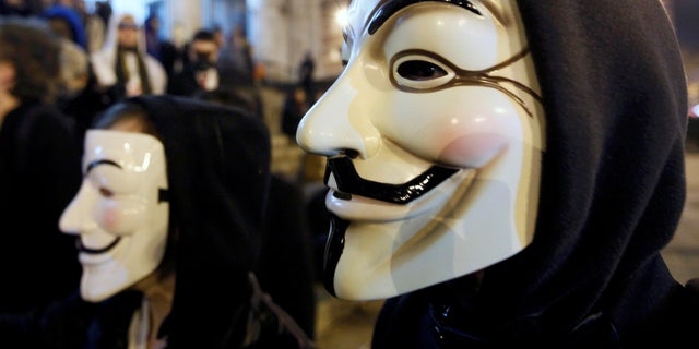 A protester wearing a Guy Fawkes mask, symbolic of the hacktivist group "Anonymous," takes part in a protest in central Brussels.  