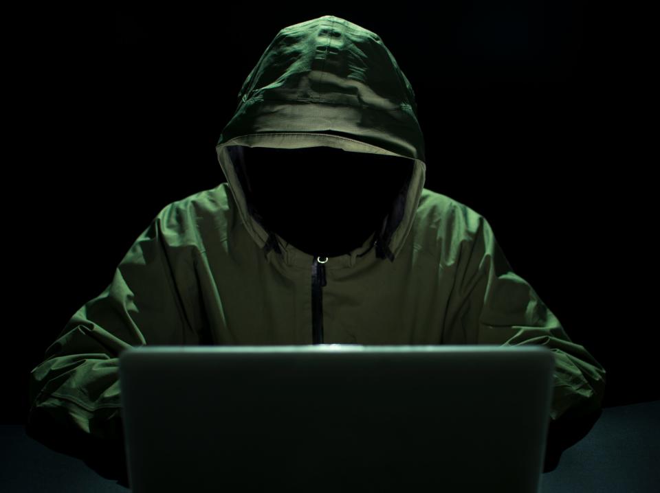 Picture of a hacker stealing password and identity in computer crime.