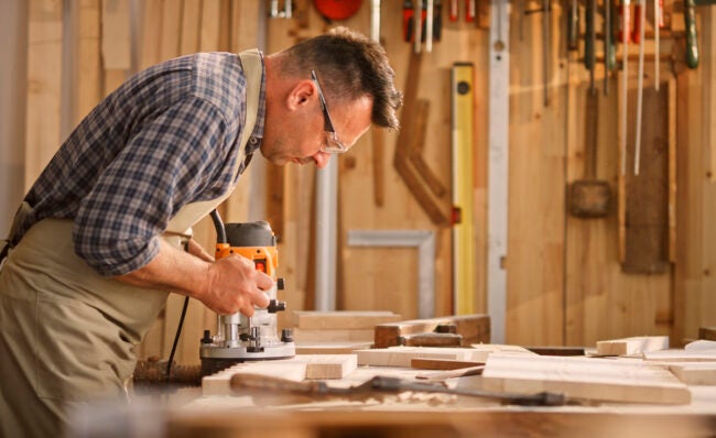 how to use a router - man using woodworking router